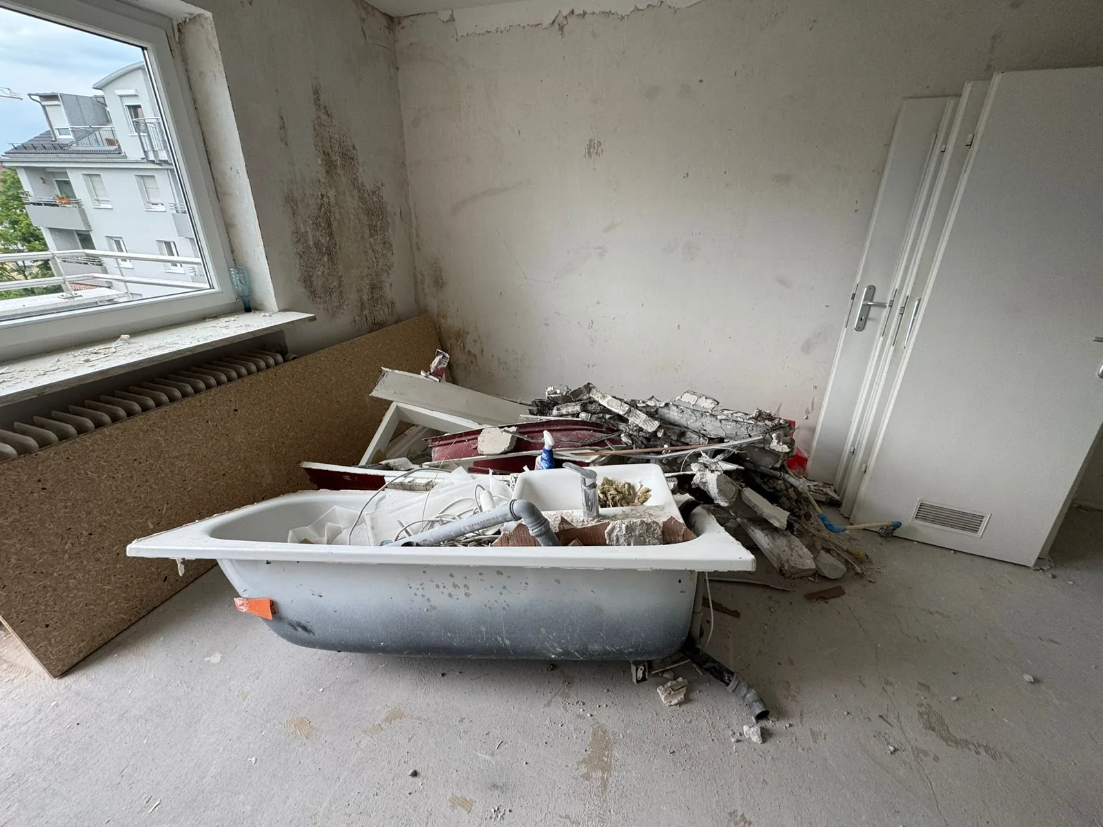 Bathroom stripped back to bare walls before renovation in Munich