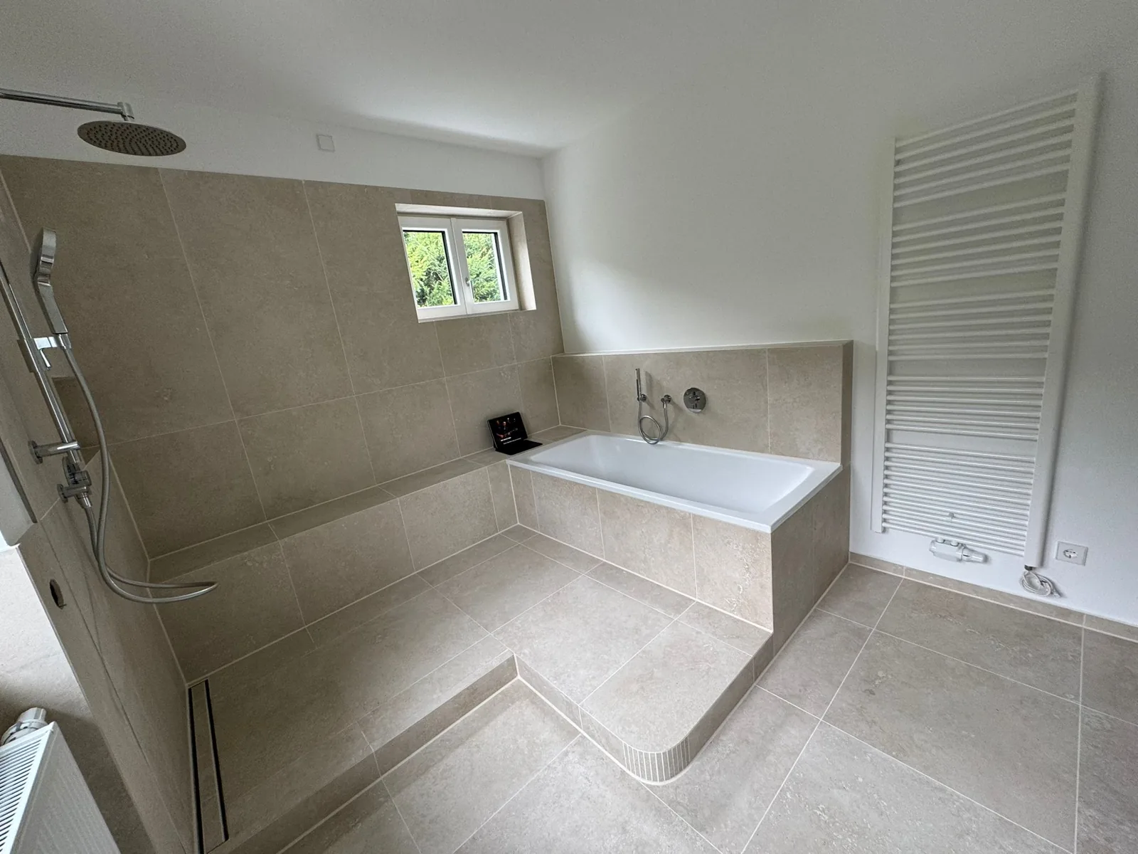 Beige travertine bathroom with bathtub and rainfall shower