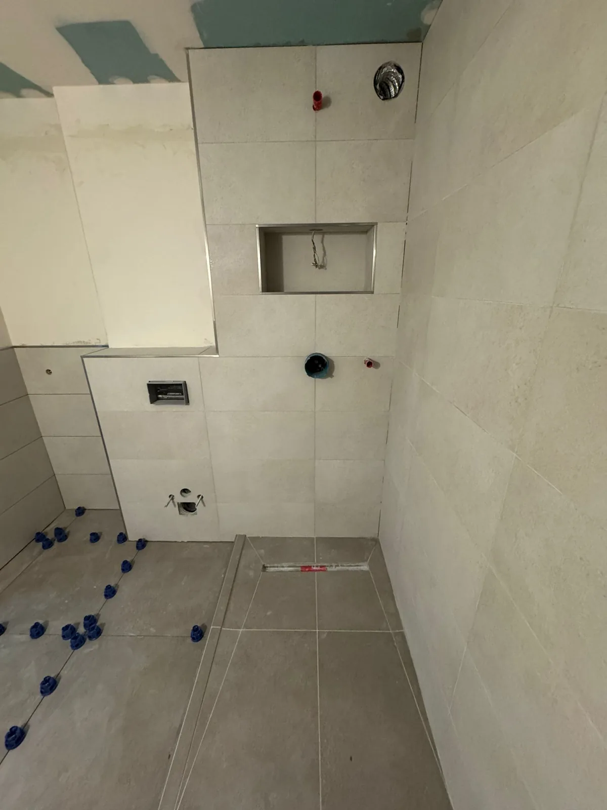 Walk-in shower mid-tile with niche and linear drain