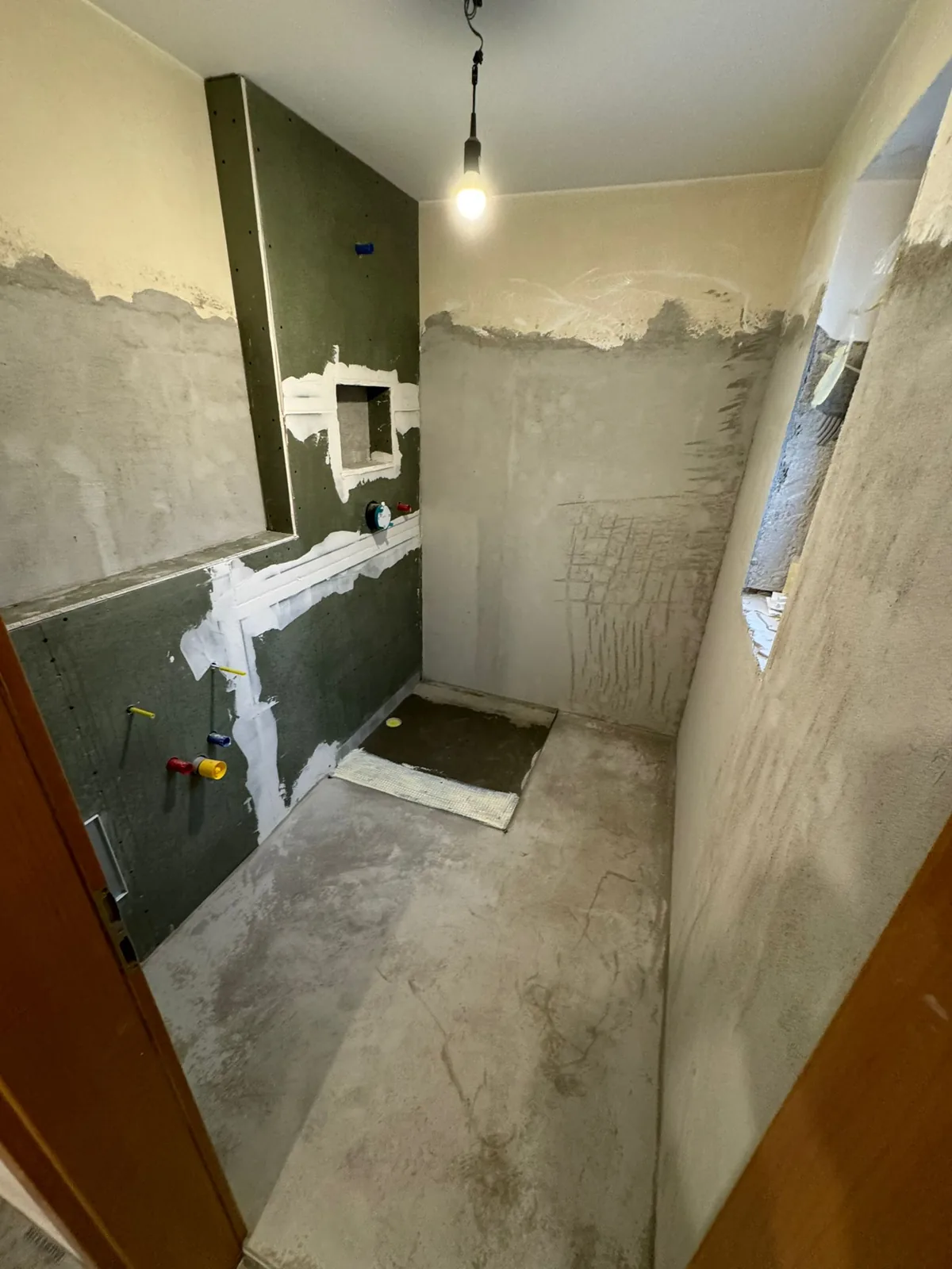Bathroom rough-in with waterproof board and colour-coded pipes