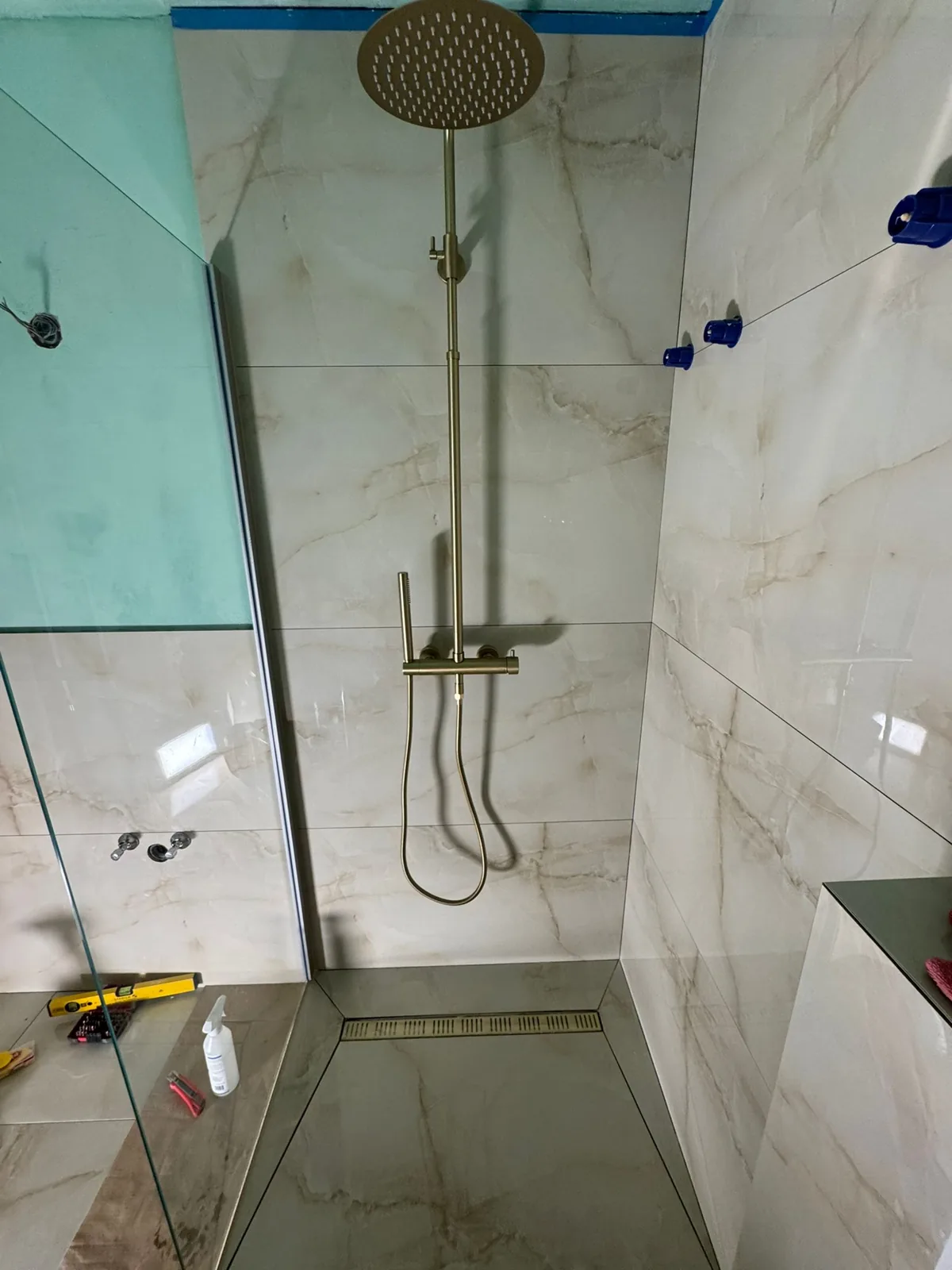 Brushed-gold walk-in shower tiling detail